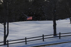 Una bandiera americana in un campo coperto dalla neve a Gilmanton, New Hampshire